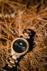 Reloj Vernoir con caja de madera de Zebrano y malla de Chacate Preto con incrustaciones de madera de Zebrano. Esfera negra con marcadores minimalistas en blanco y manecillas negras.