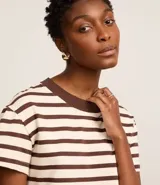 Remera de algodón a rayas horizontales color crema y marrón, con cuello redondo marrón.