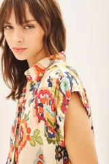 Camisa de corte amplio con cuello camisero y botones a tono.