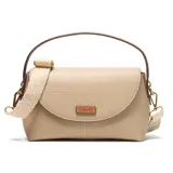 Bandolera de material símil cuero color taupe, con solapa frontal redondeada y cierre superior. Posee correa larga regulable y desmontable, y herrajes metálicos dorados. Lleva un logo metálico de la marca XL aplicado al frente.