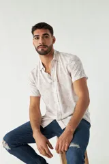 Camisa de hombre estampada, de manga corta y fit slim. Presenta cartera abotonada y logo bordado.