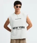 Musculosa negra de algodón con corte recto y hombros ligeramente ampliados (boxy fit). Presenta estampado frontal en blanco con el texto "URBAN SCENE TRENDS", "NEW YORK" y "Manhattan 1974".