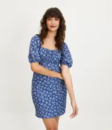 Vestido corto azul con estampado floral blanco, escote cuadrado, mangas cortas abullonadas y textura.