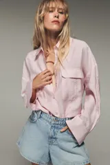 Camisa blanca de modal con cuello solapa, manga larga con puños abotonados, cierre frontal con botones y dos bolsillos con solapa en el pecho.