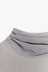 Vestido midi color gris topo, de cuello halter con lazada combinada a tono. Bajo con abertura en espalda. Cierre en espalda con cremallera, abertura y botón.