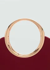 Bolso pequeño color borgoña, con efecto piel y asa de mano circular dorada. Incluye forro interior, detalle metálico, doble asa corta y asa larga extraíble. Cierre de imán interior.