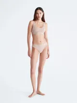 Colaless color beige con encaje floral semitransparente y cintura elástica con logo Calvin Klein.