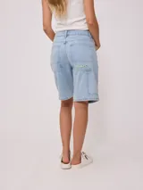 Bermuda de jean celeste con bolsillos delanteros y traseros.