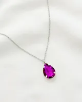 Collar plateado con dije de cristal en forma de lágrima color fucsia.