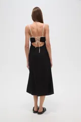 Vestido largo negro, de corte al cuerpo, con escote profundo y tirantes ajustables con reguladores.