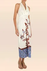 Vestido largo color crema con estampado de flores y hojas en tonos marrón y celeste. Tiene escote halter con tiras que se atan en la nuca y falda con vuelo.