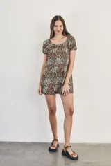 Vestido corto de viscosa con estampado floral en tonos beige, marrón y negro. Tiene escote redondo con frunce y mangas cortas.