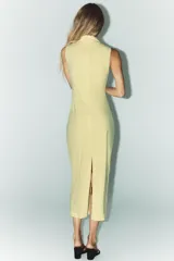 Vestido midi amarillo pálido, sin mangas, con cuello alto y detalle drapeado en el lateral.