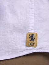 Camisa verde militar de manga larga, confeccionada en mezcla de lino y algodón. Tiene cuello clásico, cierre con botones y un bolsillo en el pecho.