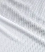 Remera deportiva gris de poliéster con cuello redondo y mangas cortas. Presenta un diseño degradado en el frente y protección UV.