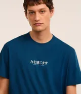 Remera azul de algodón con cuello redondo y manga corta. Presenta un estampado en la espalda con una carpa koi, un edificio tradicional japonés y la palabra "Yokohama".