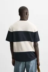 Camiseta negra relaxed fit confeccionada en tejido de algodón compacto con estructura piqué, cuello redondo y manga corta.