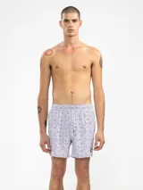 Short de baño rosado con estampado de lunares blancos, cintura elástica con cordón ajustable, bolsillos laterales y trasero con cierre, y suspensor de malla fina hipoalergénica.