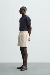 Bermuda de algodón color marrón oscuro, de corte regular fit, con cintura elástica ajustable mediante cordón. Presenta bolsillos laterales y un bolsillo trasero de vivo.