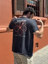 Camiseta negra de manga corta con estampado en la espalda del logo de Brixton y una flor de hibisco.