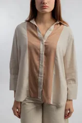 Camisa color beige con solapas y cierre con botones.