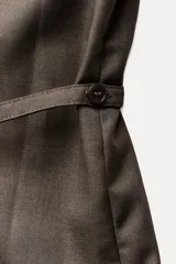 Camisa marrón de Zara Woman Collection, confeccionada en hilatura con viscosa. Tiene cuello solapa, manga larga con puño, bolsillo de plastrón en el pecho, cinturón ajustable con lazadas y bajo asimétrico. Se cierra con botones frontales.