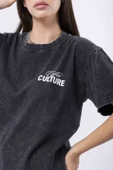 Remera oversize de algodón con efecto acid wash negro/gris, cuello redondo y manga corta. Estampado frontal pequeño con la palabra "Culture" en blanco.