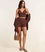 Top cropped color marrón con breteles finos dobles, escote en pico y cierre trasero con cremallera.