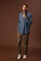 Camisa celeste con rayas horizontales en tonos beige y gris, de corte clásico, manga larga y cuello abotonado.