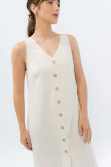 Vestido midi de lino en color verde seco, con escote en V, diseño sin mangas y cierre frontal con botones de madera. Presenta un corte recto y fluido con una abertura frontal en el bajo.