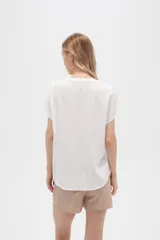 Blusa color crudo de viscosa, corte holgado, con cuello en v y cierre frontal con dos botones de madera.