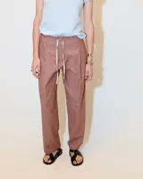 Pantalón de sarga color ladrillo, con pinzas, tiro medio, corte recto y ajuste con cordón en la cintura.