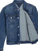 Campera Tommy Hilfiger de denim azul, corte clásico, con cuello inglés, cierre de botones, dos bolsillos tipo sobre con botón en el pecho, dos bolsillos laterales de ojal, puños con botón y logo de Tommy Hilfiger bordado en el pecho.