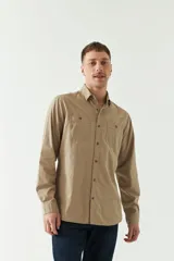 Camisa de gabardina gris con corte slim, mangas largas, cartera abotonada y dos bolsillos con solapa en el pecho.