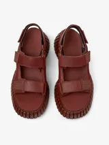 Sandalias marrones de cuero con plataforma gruesa y tiras con ajuste de velcro.
