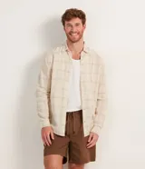 Camisa masculina regular de lino y algodón, color beige claro con estampado de cuadros grises. Tiene cuello inglés, mangas largas y abotonadura frontal.