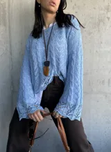 Sweater celeste de hilo con calados y mangas largas acampanadas.