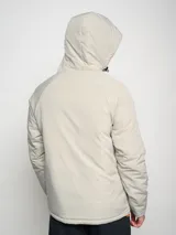 Campera corta de abrigo Umbro Crafted Pro, color negro con paneles laterales en gris. Presenta capucha con cordón ajustable, cierre frontal completo y logo de la marca bordado en el pecho.