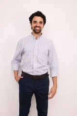 Camisa de manga larga con estampado a cuadros en tonos azul, gris y blanco. Tiene cuello abotonado, bolsillo en el pecho y corte clásico.