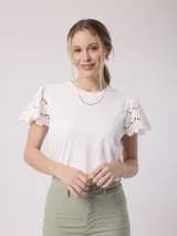 Remera blanca de poliéster y spandex con mangas cortas con volados de encaje.