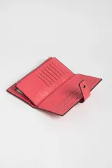 Billetera larga color fucsia con textura símil piel de serpiente, cierre con broche a presión y cierre de cremallera.