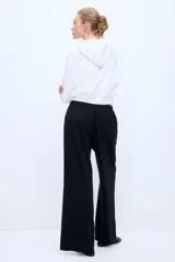 Pantalón negro de corte holgado en punto suave, con piernas rectas y elástico revestido con cordón para ajustar en la cintura.