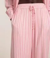 Pantalón de cambraia color rosa con rayas verticales blancas, de corte recto y cintura alta con elástico y lazo.