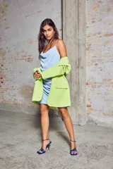 Blazer verde lima de corte oversize, con cuello de solapa, cierre de un botón y bolsillos delanteros con solapa.