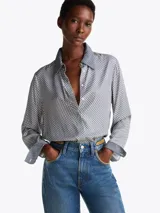 Camisa celeste con estampado de lunares blancos, de corte regular, cuello francés, cartera oculta y puños con un botón.