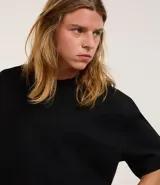 Remera color crema de corte amplio, con cuello redondo y mangas cortas con sisa desplazada. Confeccionada en algodón y poliéster.