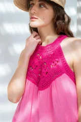 Vestido corto color naranja con escote halter de crochet tejido en hilo de algodón y falda escalonada.