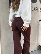 Pantalón de denim elastizado color borgoña, de corte ajustado.