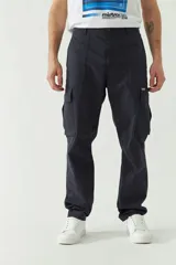 Pantalón cargo color beige para hombre, de corte recto, con bolsillos laterales y traseros. Se ajusta a la cintura con cinturón de cuero marrón.