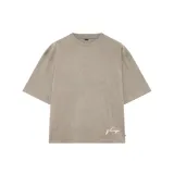 Remera beige de corte oversize con cuello redondo y mangas cortas. Estampado en la espalda con la palabra 'nenefo' en cursiva blanca.